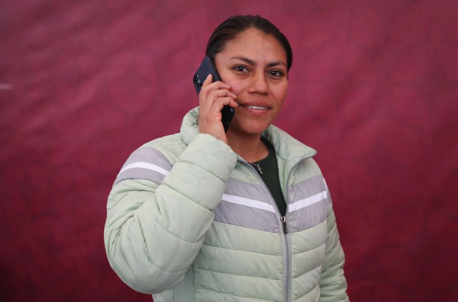 Imagen de una mujer beneficiaria del programa Mujeres con Bienestar en el Estado de México utilizando su teléfono móvil, como parte del apoyo de telefonía e internet gratis que se otorga por 90 días para fortalecer la conectividad y el bienestar digital.